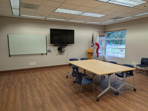 Image of the inside of the Nipomo Library Community room showing a conference table, whiteboard, and TV.