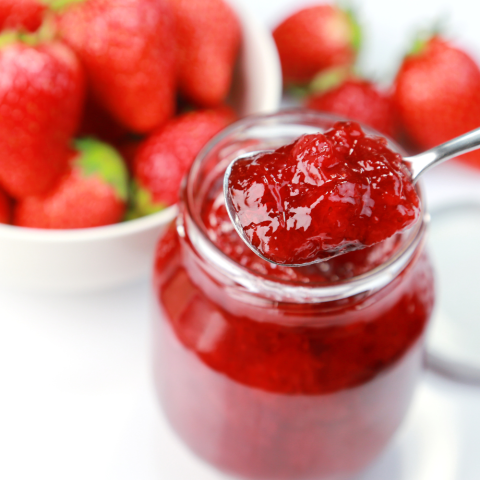 Jar of strawberry preserves with spoon
