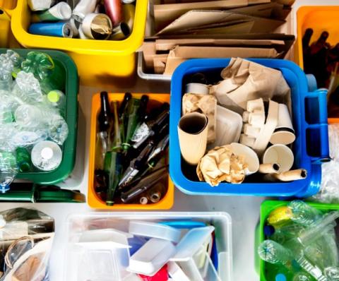 Glass, plastic, metal and paper items sorted into different bins for recycling.