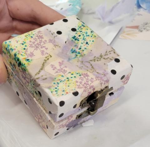 Small square box decorated with collage pattern. 