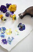 Flowers on a white sheet of paper with a hammer to the right.