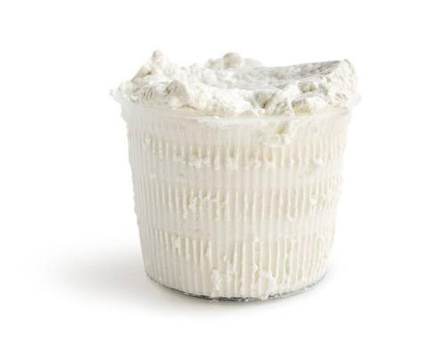 Container of white cheese on a white background.
