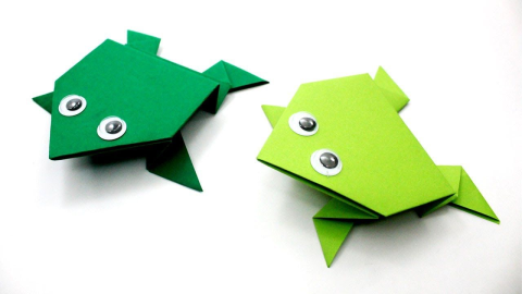 two green origami frogs