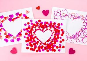 three white cards with red hearts stamped on them