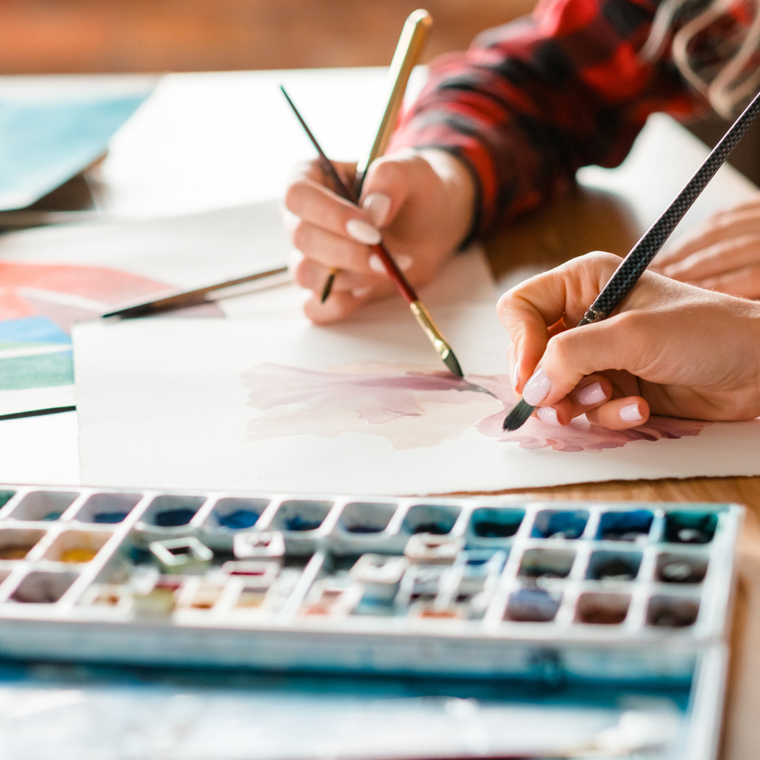 adults painting with watercolor palette